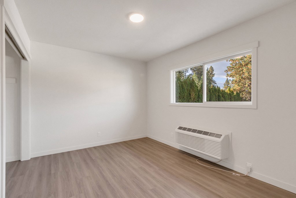 an empty room with white walls and a window