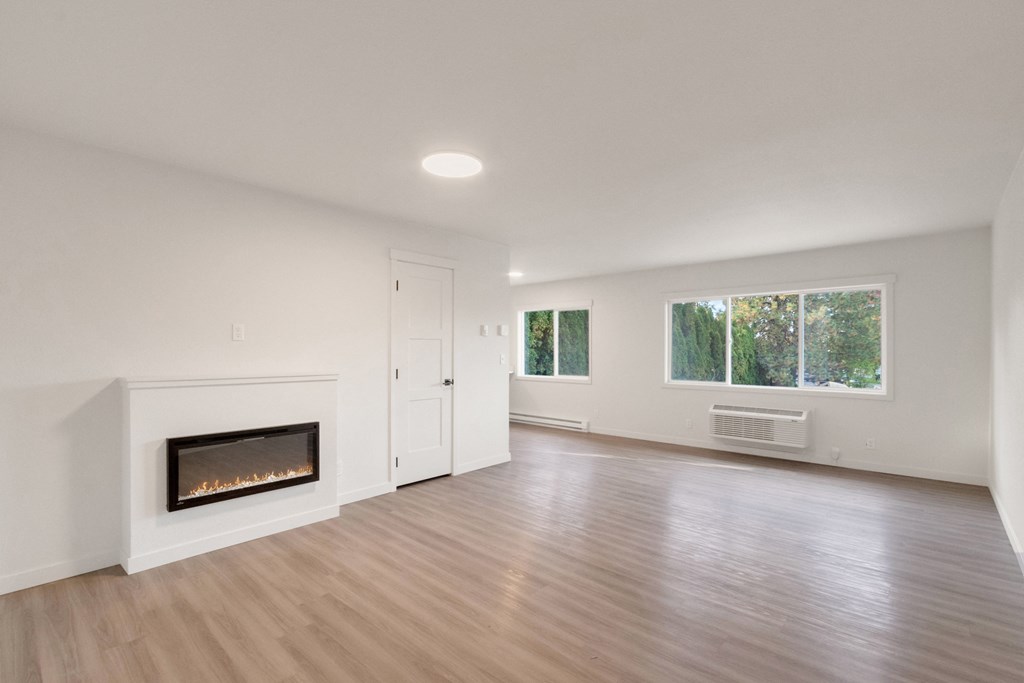 an empty living room with a fireplace and a window