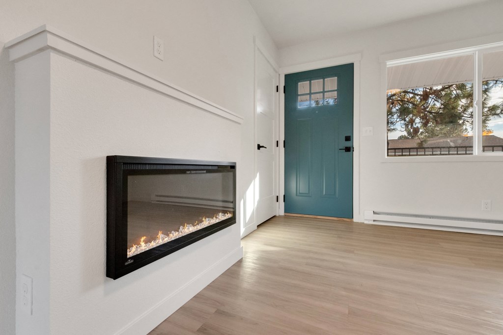 a living room with a fireplace and a blue door