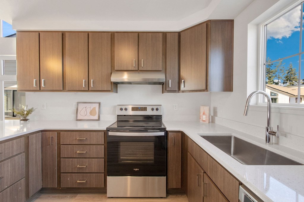 a kitchen with wooden cabinets and a stove and a sink