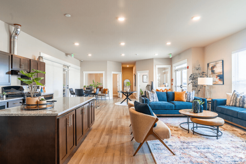 a living room with a kitchen and a blue couch