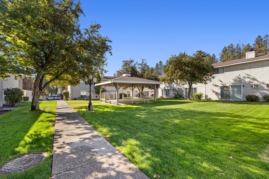 a gazebo sits in the middle of a grassy area