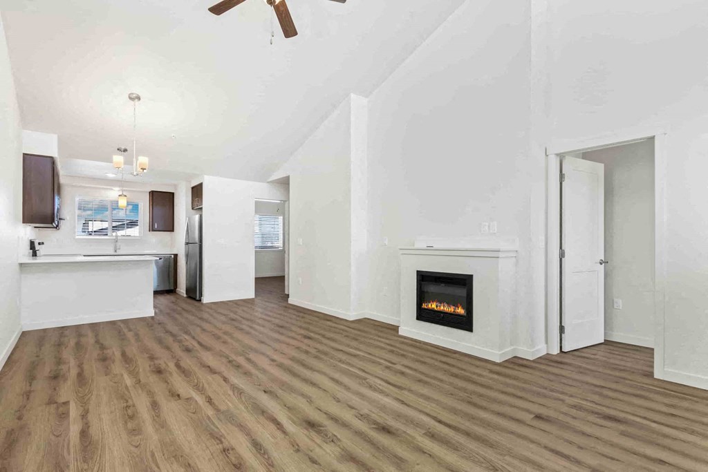 a living room with a fireplace and a kitchen
