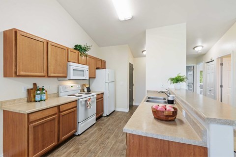A kitchen with wooden cabinets and white appliances.