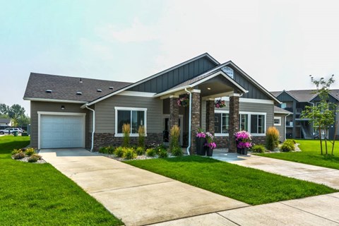 A house with a grey roof and a white garage door.