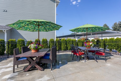 A patio with a table and chairs under green umbrellas.