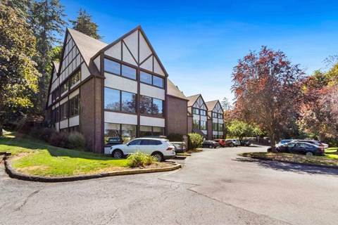 A modern building with a parking lot in front.