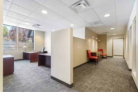 A conference room with a carpeted floor and a window.