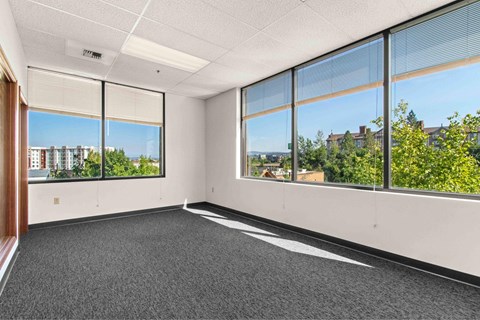 A room with large windows and a view of the city.
