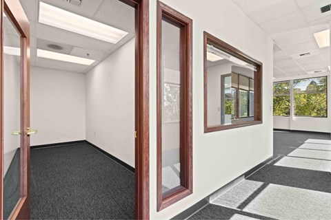 A room with a carpeted floor and a window.
