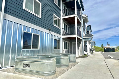 A blue and silver building with the words "Behling Country" on a planter in front.