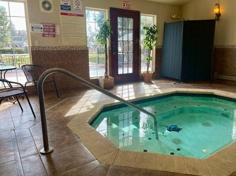 A pool with a metal ladder and a sign that says "EXIT" on the wall.