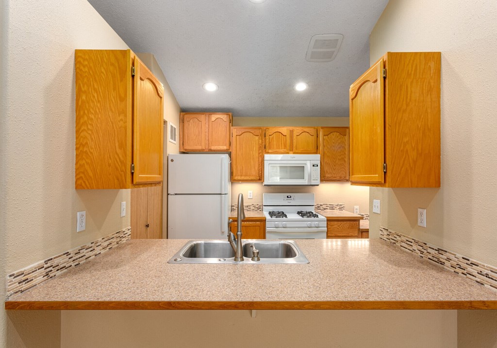 A kitchen with wooden cabinets and a white refrigerator.