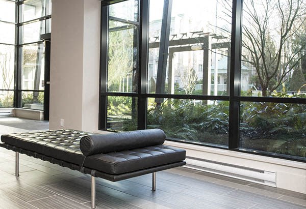 a black chaise lounge in front of a large window