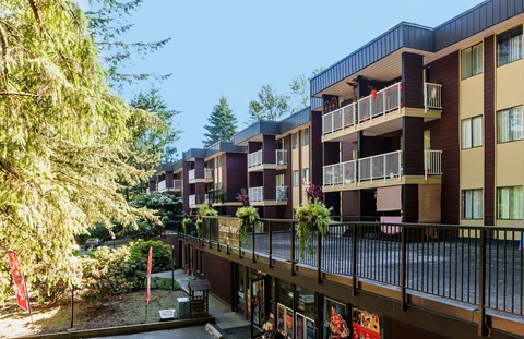 an apartment complex with balconies and trees