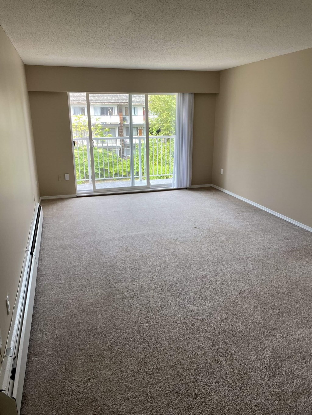 an empty living room with a balcony