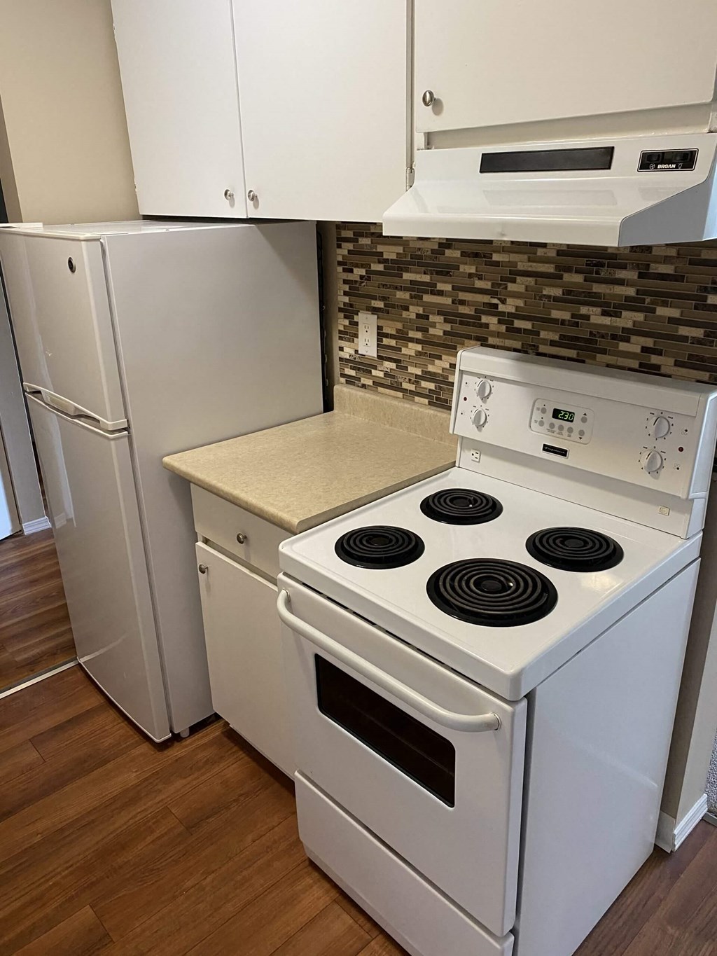 a white stove top oven sitting next to a white refrigerator