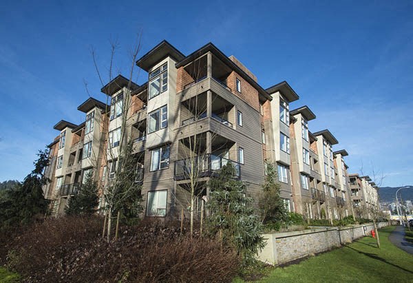 a picture of an apartment building with a blue sky in the background