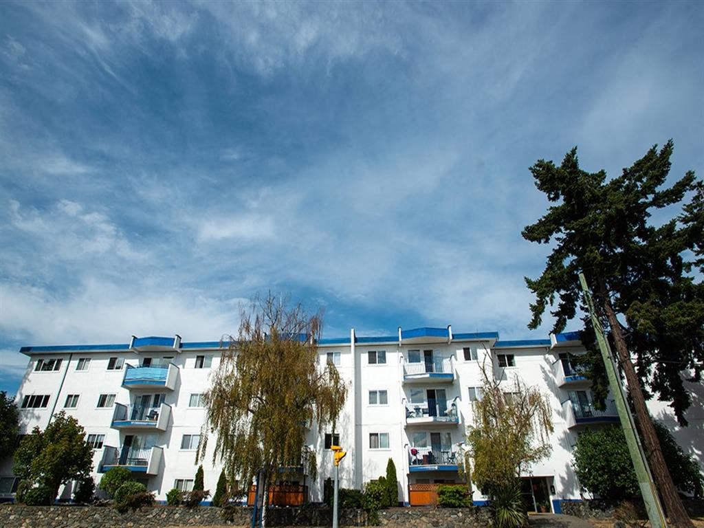 a white apartment building with a blue sky in the background