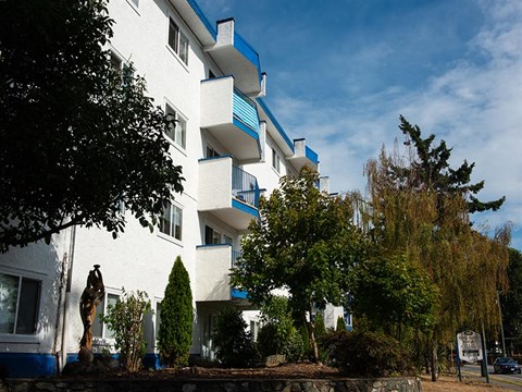 A white building with blue trim and balconies.