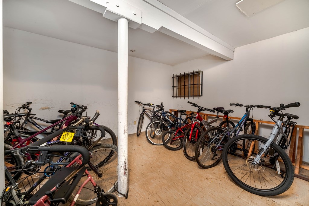 A room full of bicycles with a white pole in the middle.