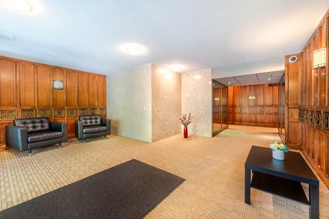 A living room with a black sofa and a coffee table.