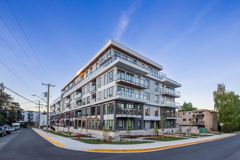 A modern multi-story building with balconies and large windows.