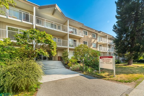 A building with a sign that says "Cold Springs Apartments" in front of it.
