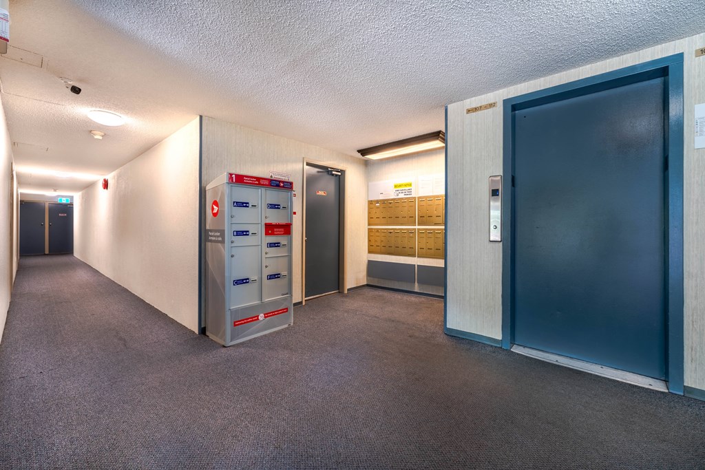 A hallway with a mailbox and a filing cabinet.