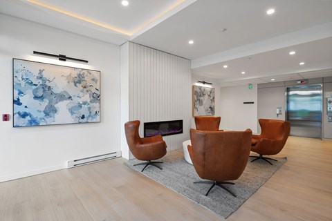 A living room with a fireplace and a painting on the wall.