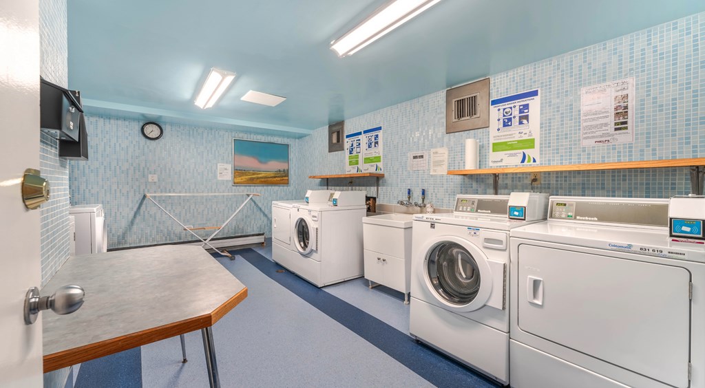 A laundromat with a row of washers and dryers.