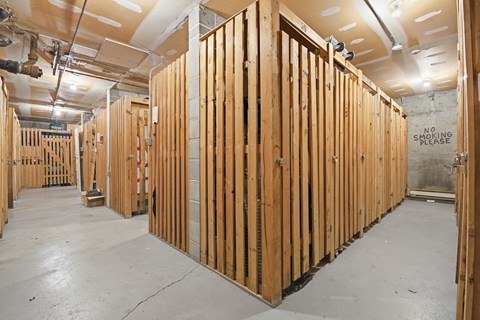 A room under construction with wooden studs and a "No Smoking Please" sign on the wall.
