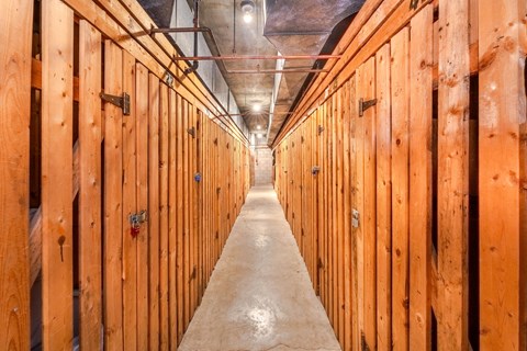 A long hallway with wooden walls and a concrete floor.