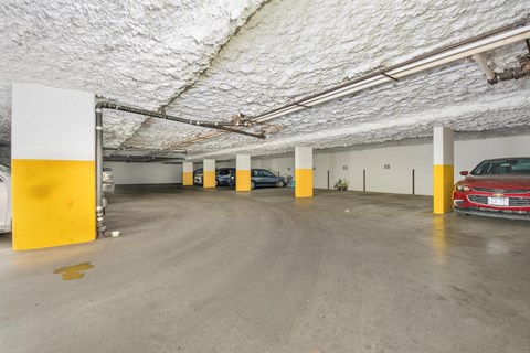 A parking garage with a red car parked in the bottom right.