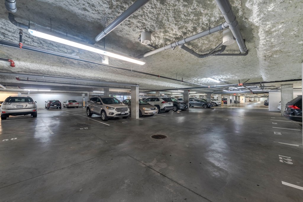 A parking garage with multiple cars parked.