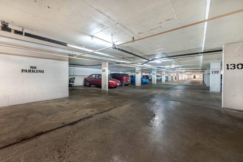 A parking garage with a "NO PARKING" sign on the wall.