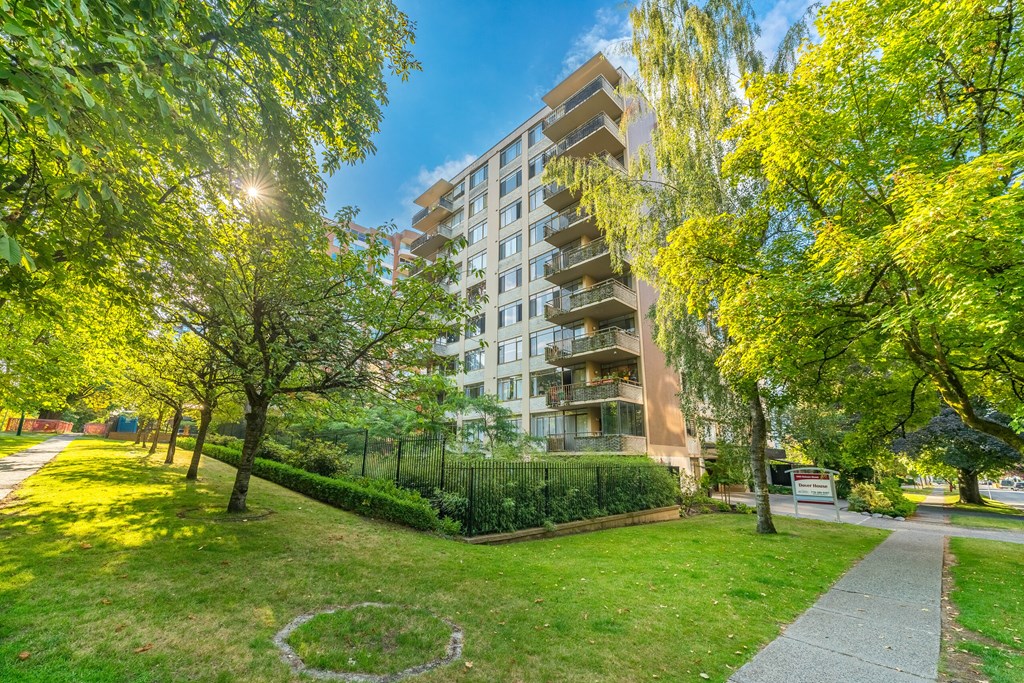A sunny day in a park with a building in the background.