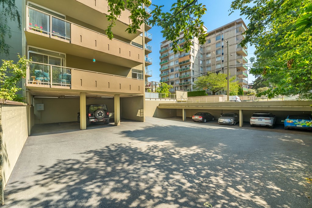 A parking lot with cars and a building in the background.