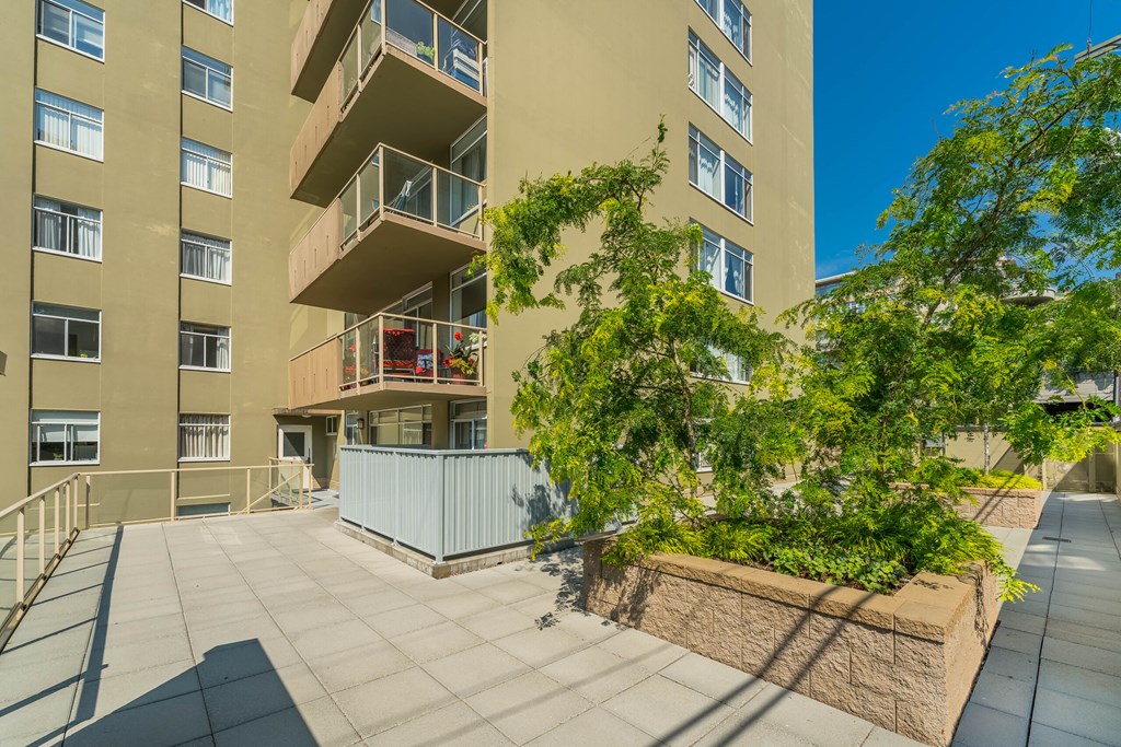 A large building with a balcony and a tree in front of it.