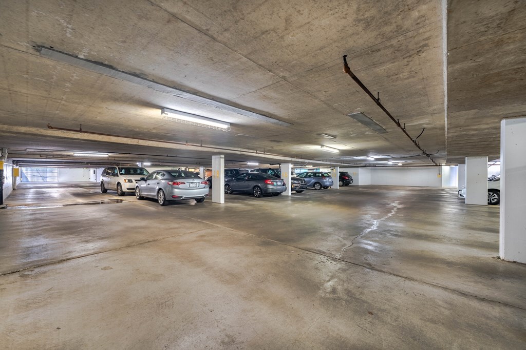 A parking garage with several cars parked in it.