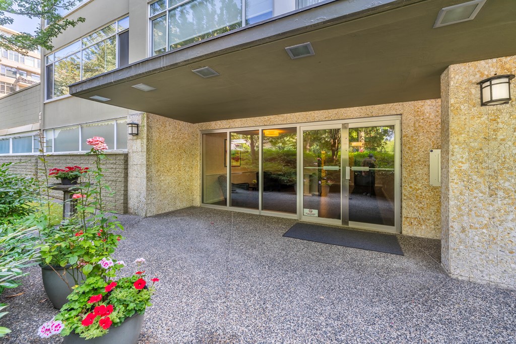 A patio area with a glass door entrance and a potted plant.