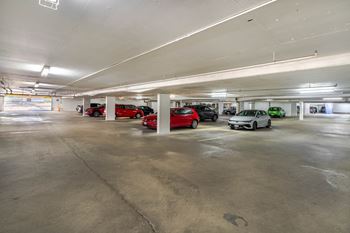 A parking garage with several cars parked in it.