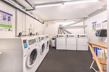 A laundry room with washing machines and a dryer.