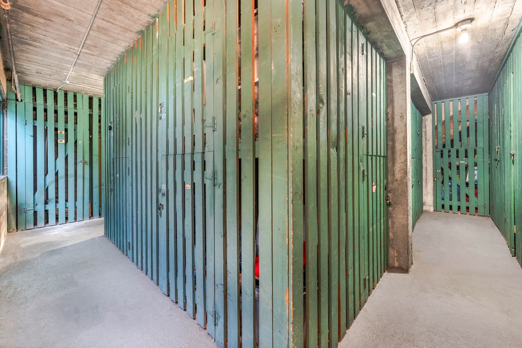 A long hallway with green walls and concrete floors.