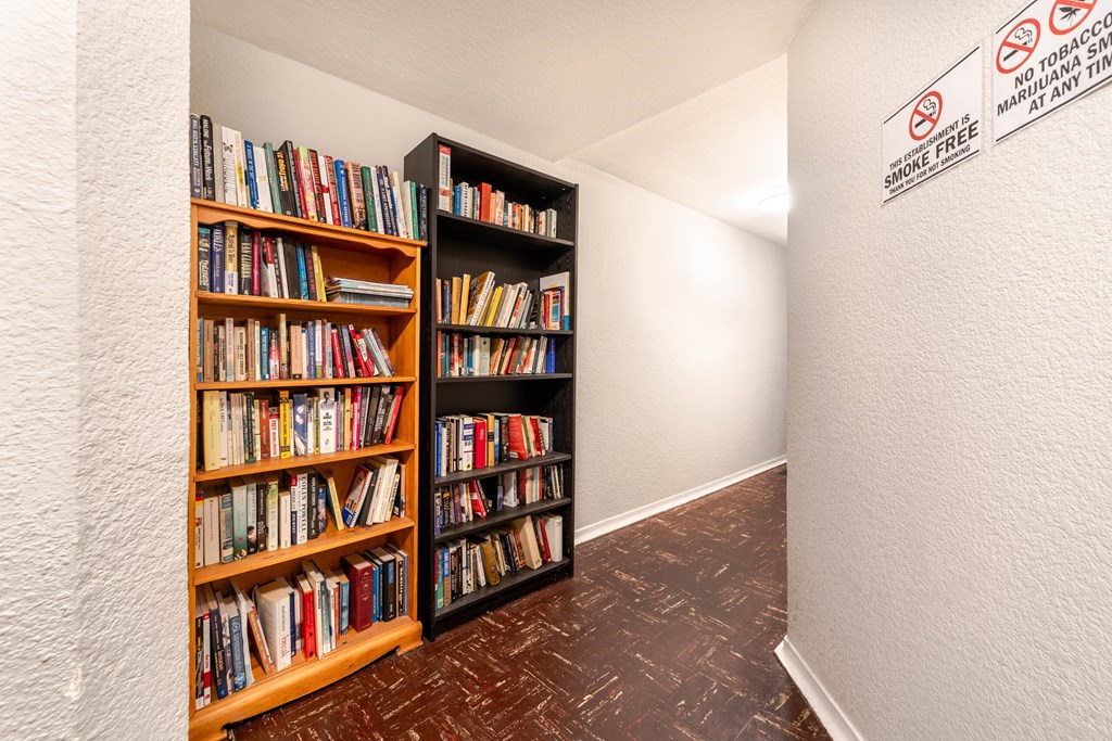 A room with a bookshelf and a no smoking sign.