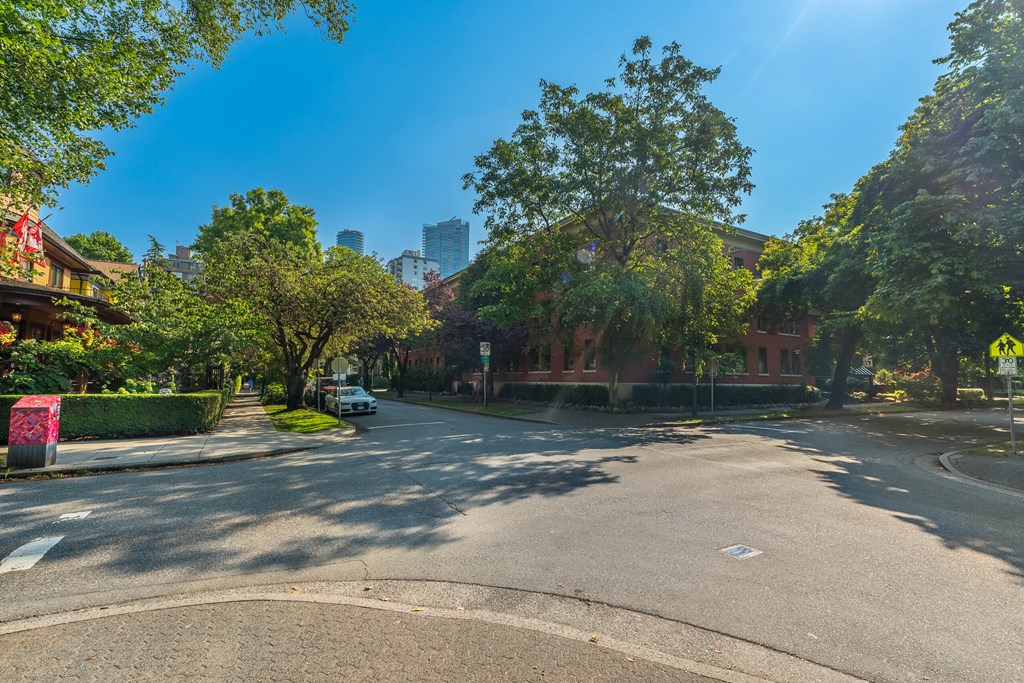 A tree-lined street with a car parked on the side.