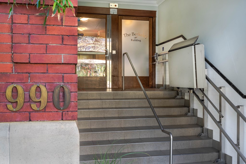 A set of stairs leading to a door with a sign that says "The Berkley Building".