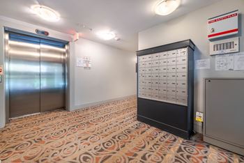 A room with a patterned carpet and a large electrical panel on the wall.