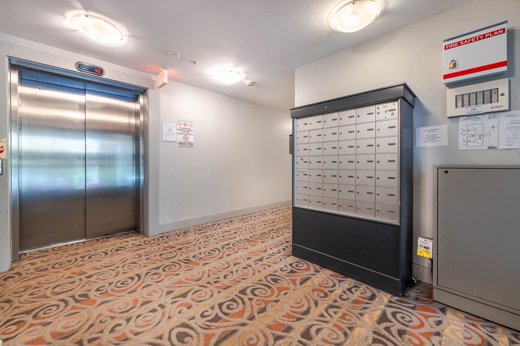 A room with a patterned carpet and a large electrical panel on the wall.