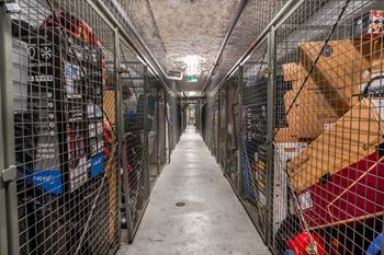 A long hallway with metal fencing and boxes on the side.